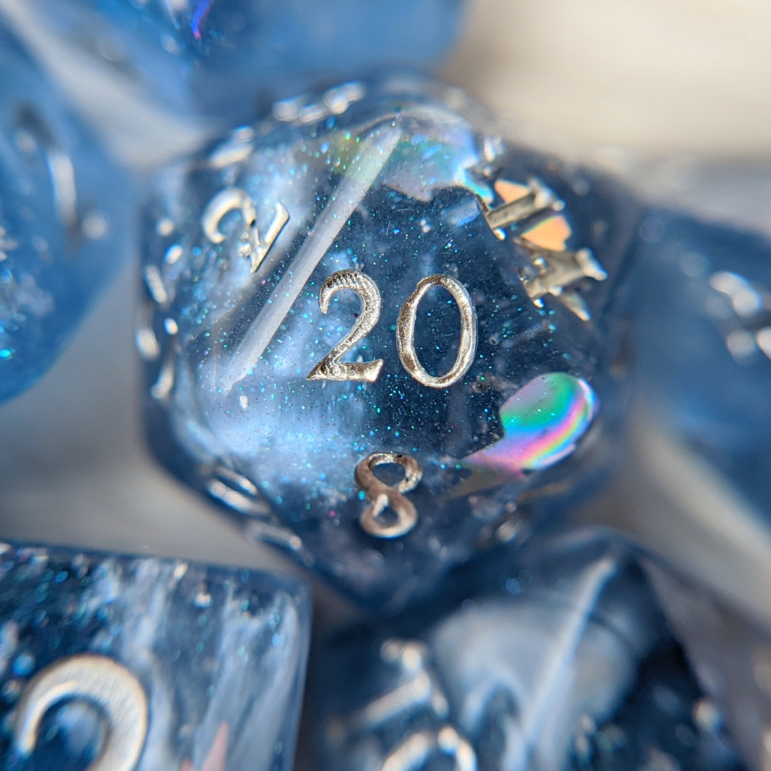 Close-up of a glittery blue resin D20 die showcasing intricate design and colorful reflections, perfect for tabletop RPG gaming.
