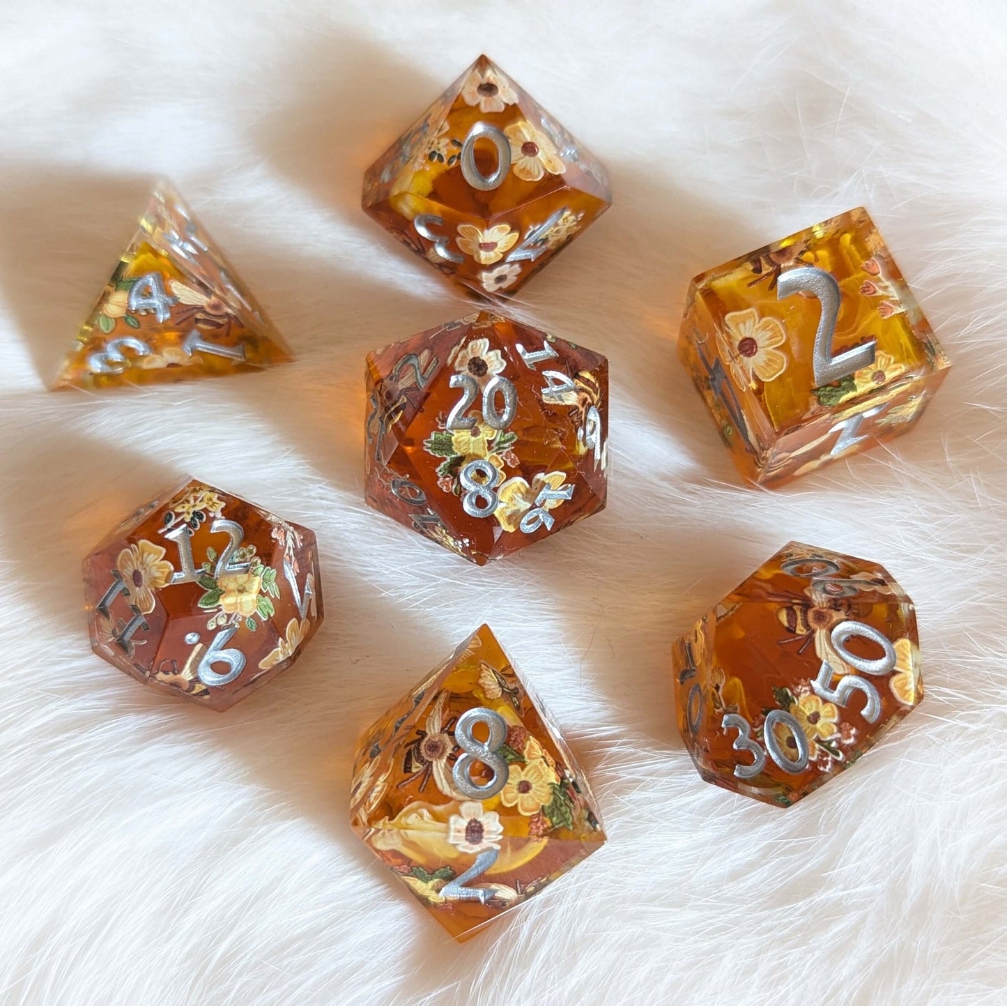 Honey Blossom sharp-edge dice set with floral and bee designs on a soft fur background.