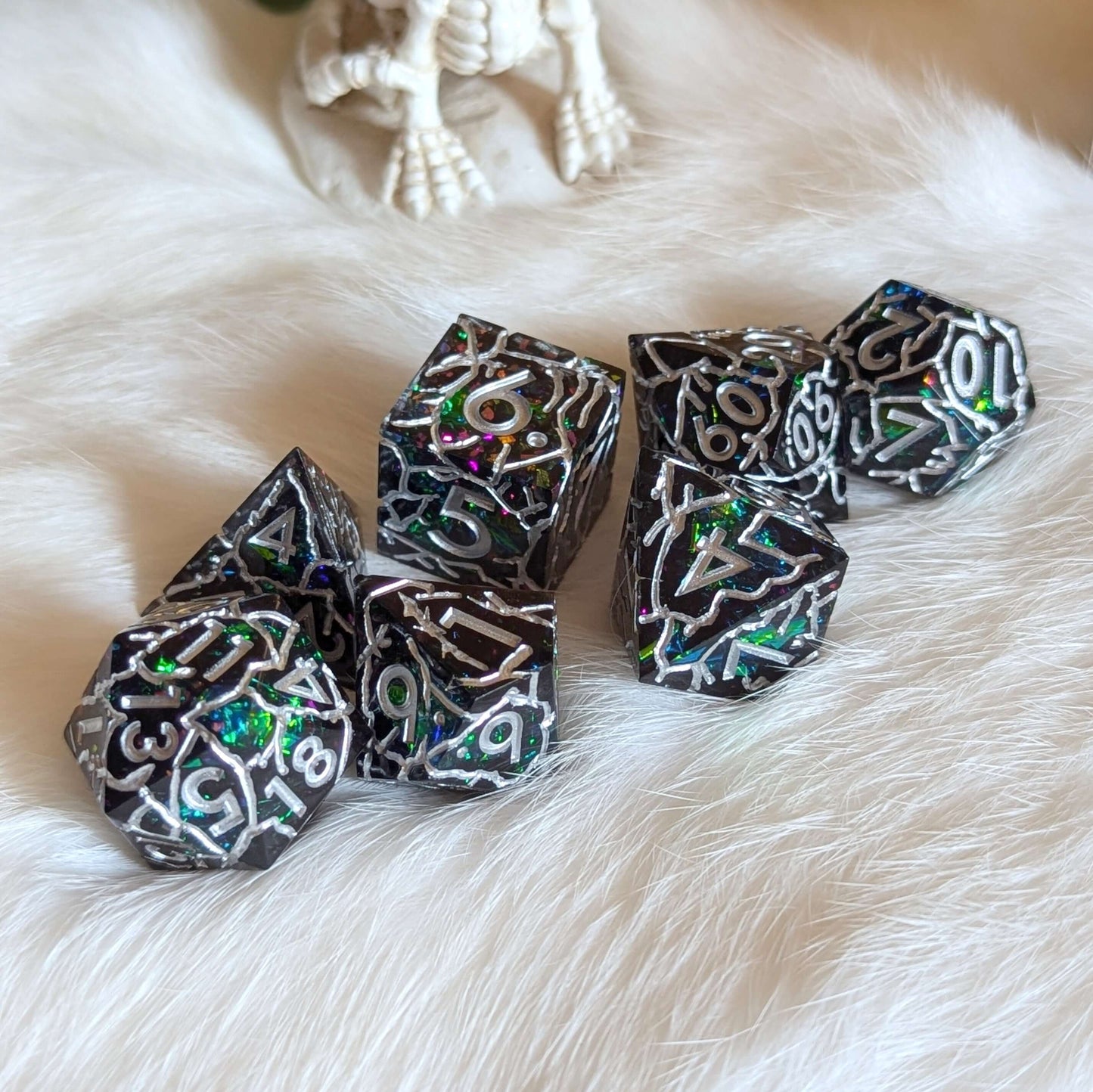 Stormlight Surge Sharp-Edged Dice Set with lightning-like cracks and shimmering silver numbers displayed on a plush surface.