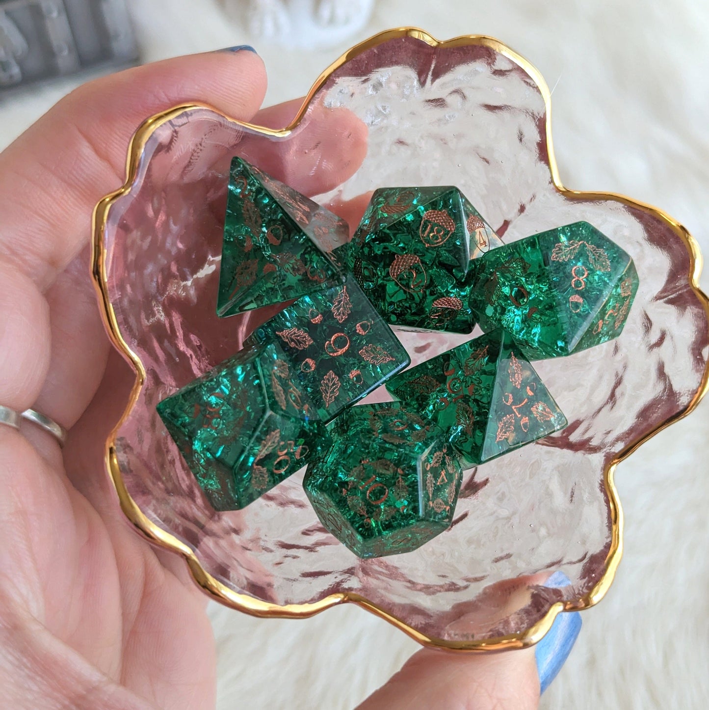 Green lightning glass dice set with acorn and oak design in a pink glass bowl, perfect for tabletop gaming adventures.