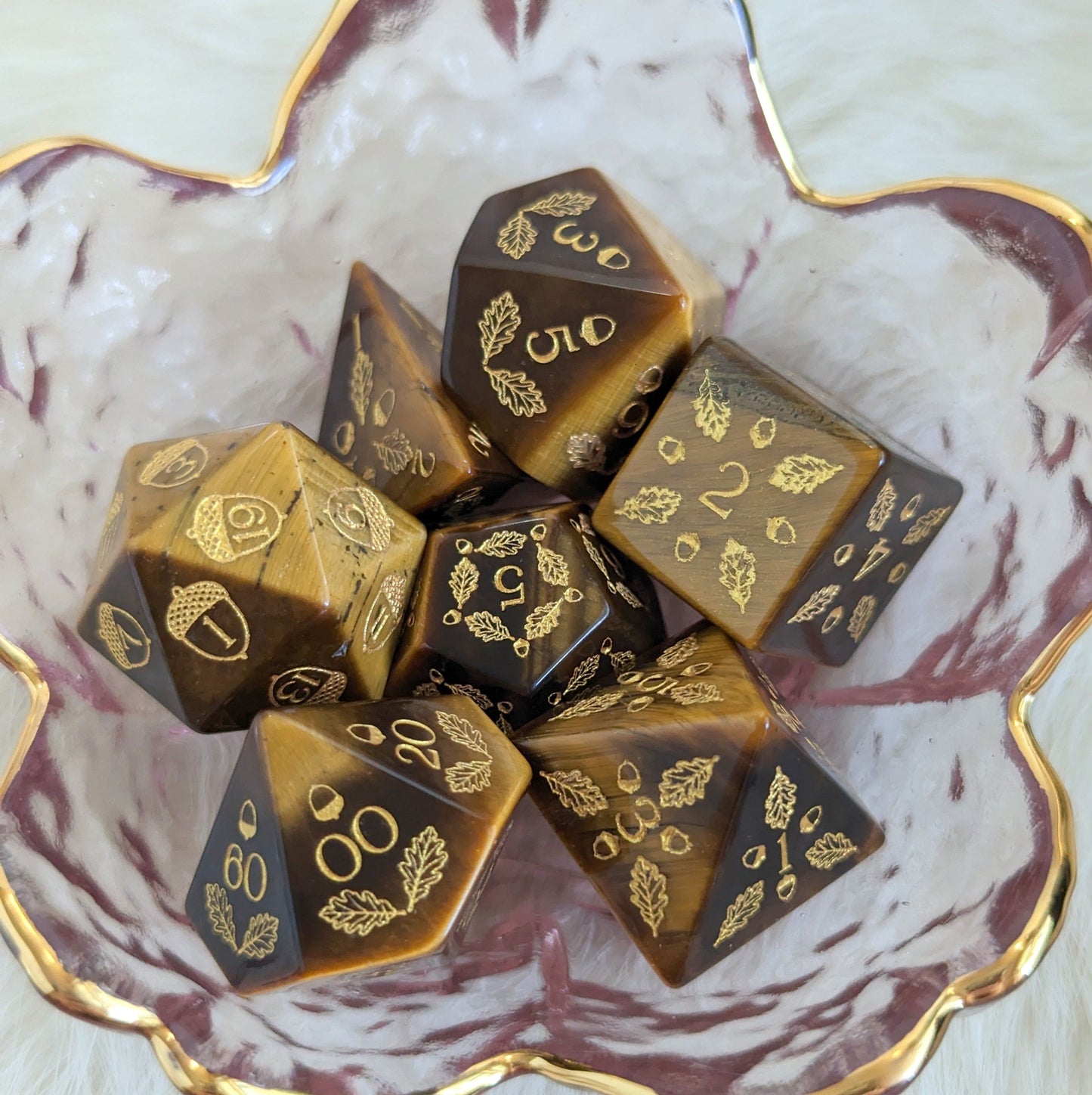 Acorn and Oak Tiger Eye Dice Set with carved acorn and oak leaf design displayed in decorative bowl