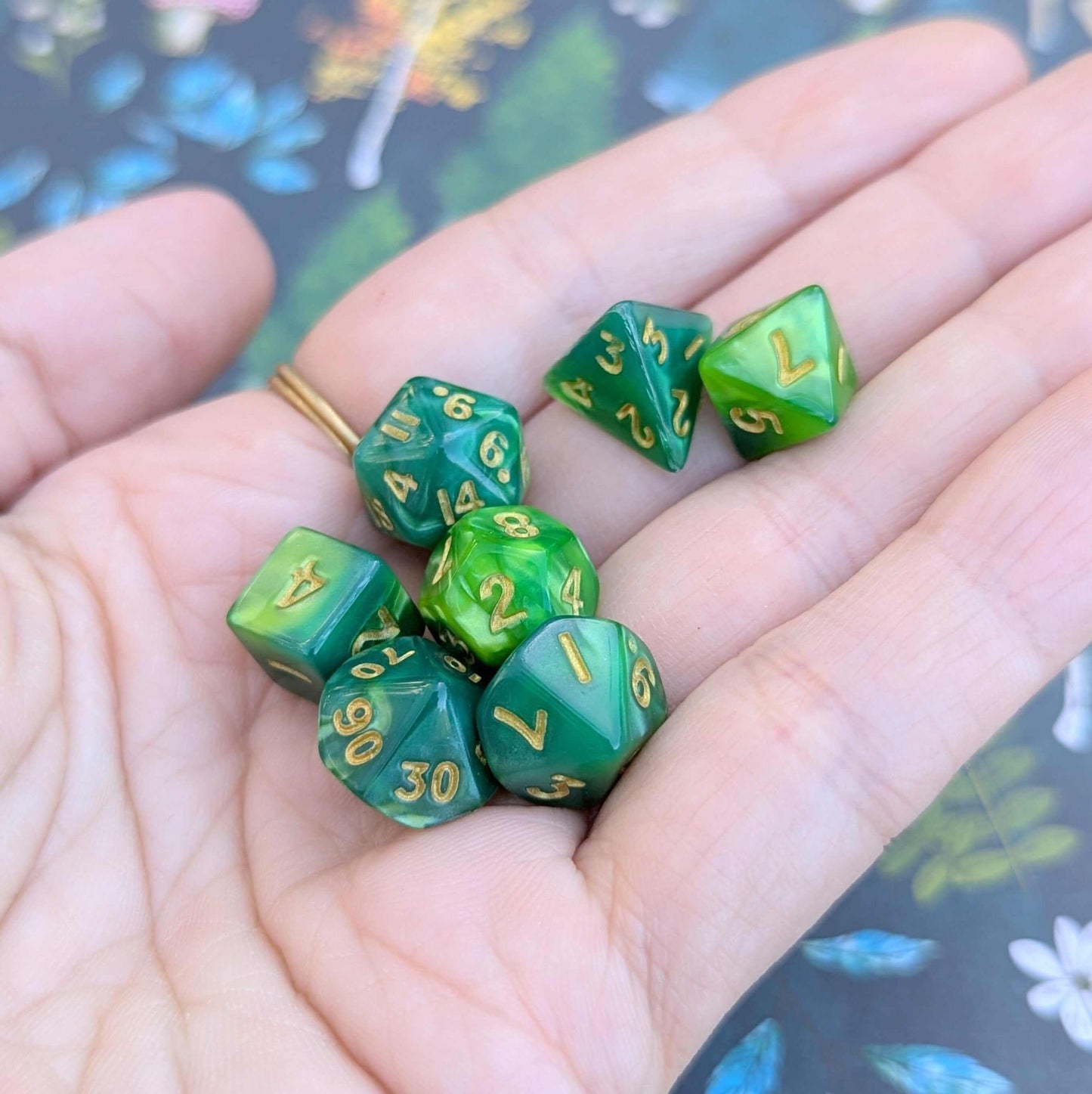 Pearly green Archer's Mini Dice Set with gold numbers in a hand, perfect for Dungeons & Dragons and other TTRPGs.