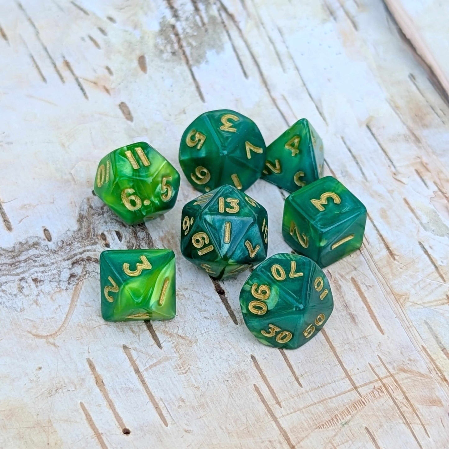 Pearly green Archer's Mini Dice Set for TTRPGs with gold numbers on rustic background