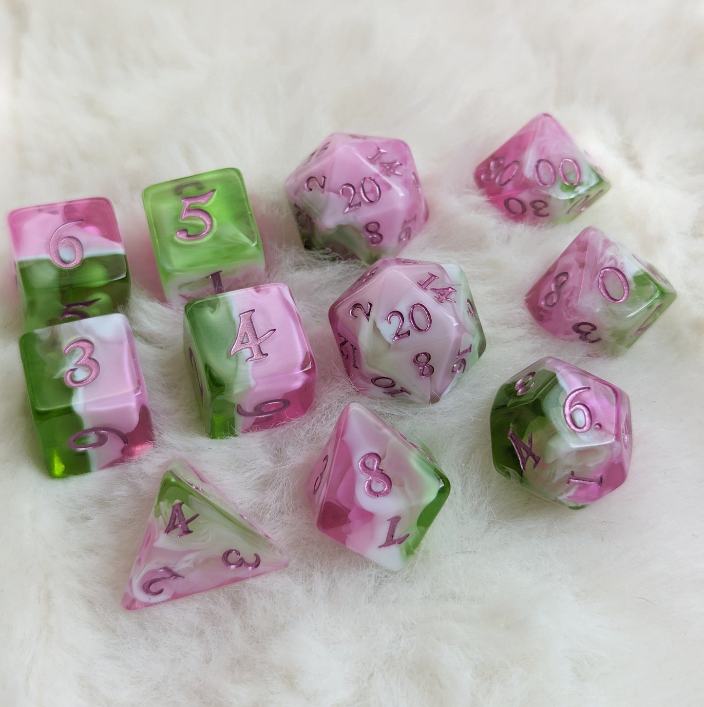 Bardic Inspiration Dice Set with pink, white, and green colors, featuring metallic magenta numbers on fluffy background.