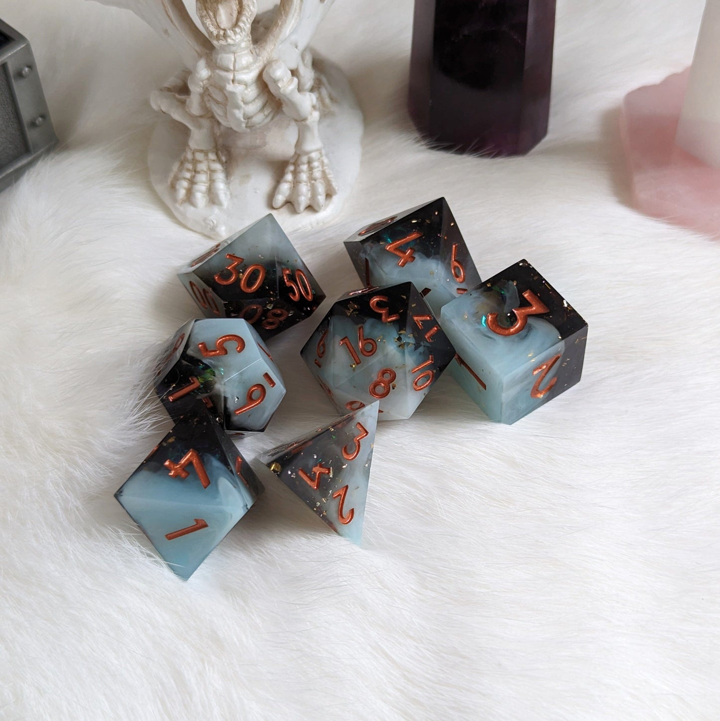 Black and white layered DnD dice set with copper font on a white surface, perfect for TTRPG games.