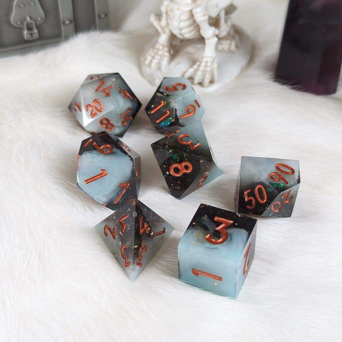 Black and white layered 7-piece DnD dice set with copper font, perfect for TTRPG sessions, displayed on a white surface.