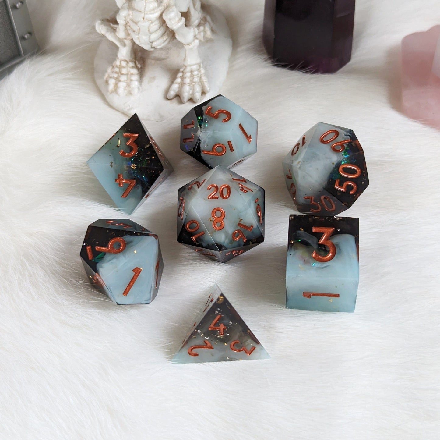 Black and white layered DnD dice set with sharp edges and copper numbers, perfect for tabletop role-playing games.