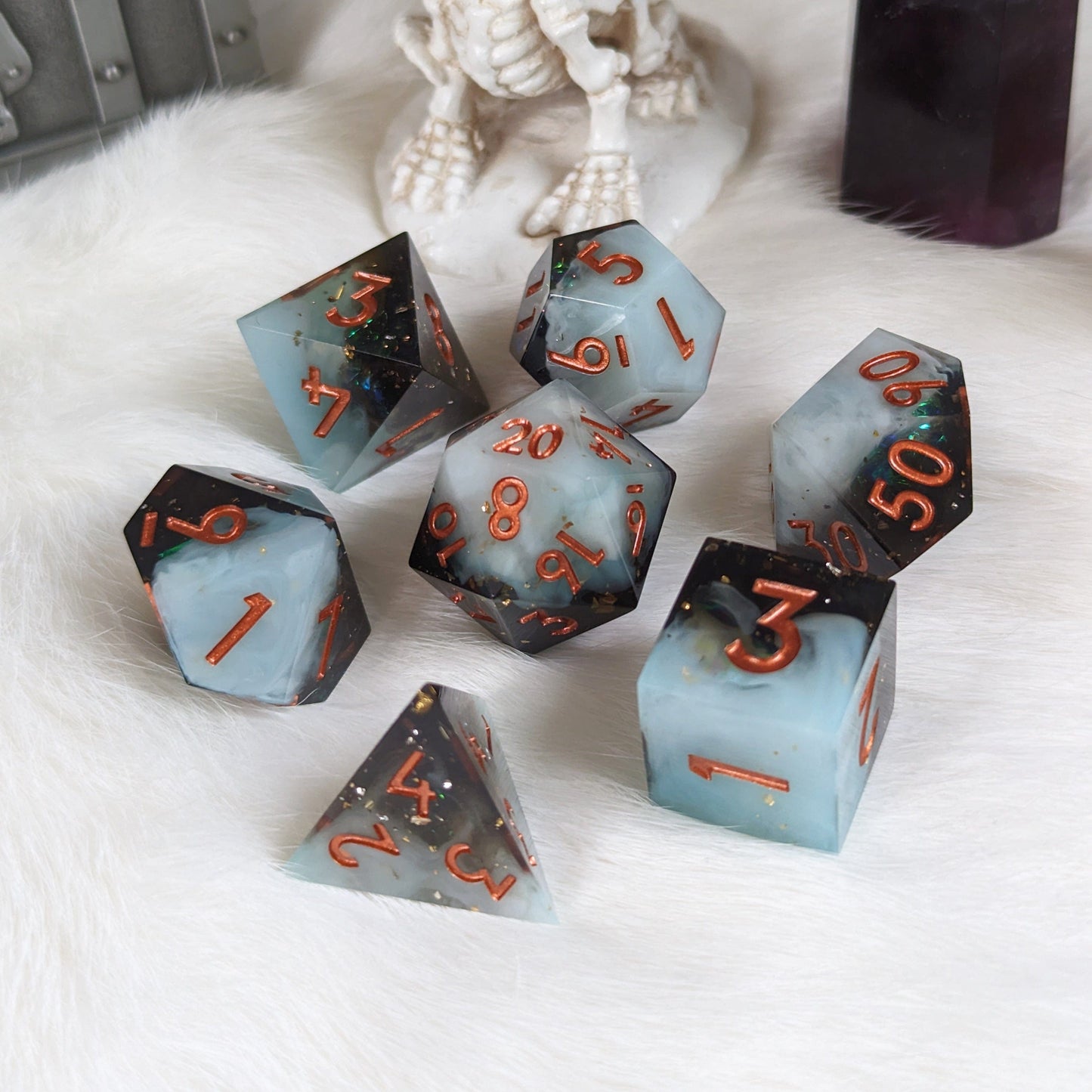 Black and white layered DnD dice set with copper font, sharp edge design, displayed on a white surface.