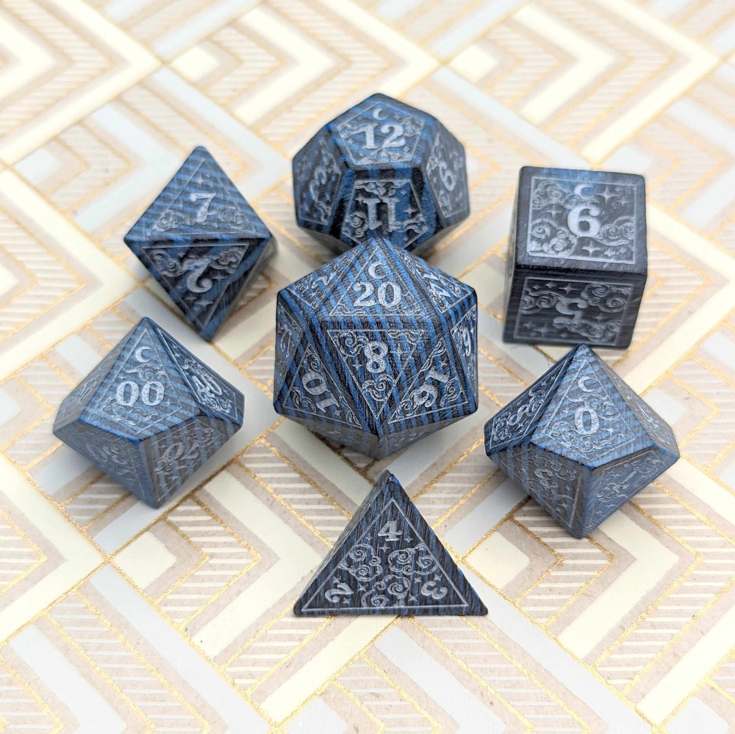 Blue Dreamy Star and Moon Wood Dice Set for Dungeons & Dragons, featuring intricate designs on a gold geometric background.