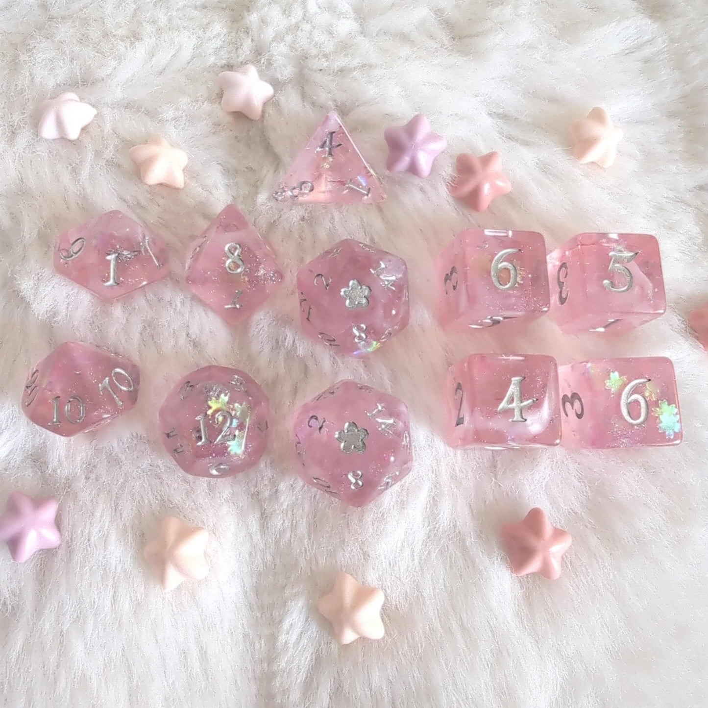 Cherry Blossom Dice Set with pink hue, silver numbers, and floral glitter, featuring a D20 with a 5-petal flower design on soft background.