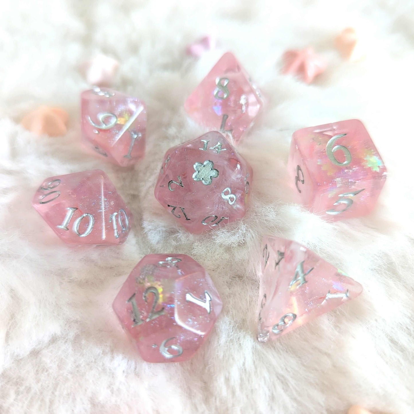 Cherry Blossom Dice Set with pink, pearly design, silver numbers, and flower glitter on plush fabric, featuring seven dice.