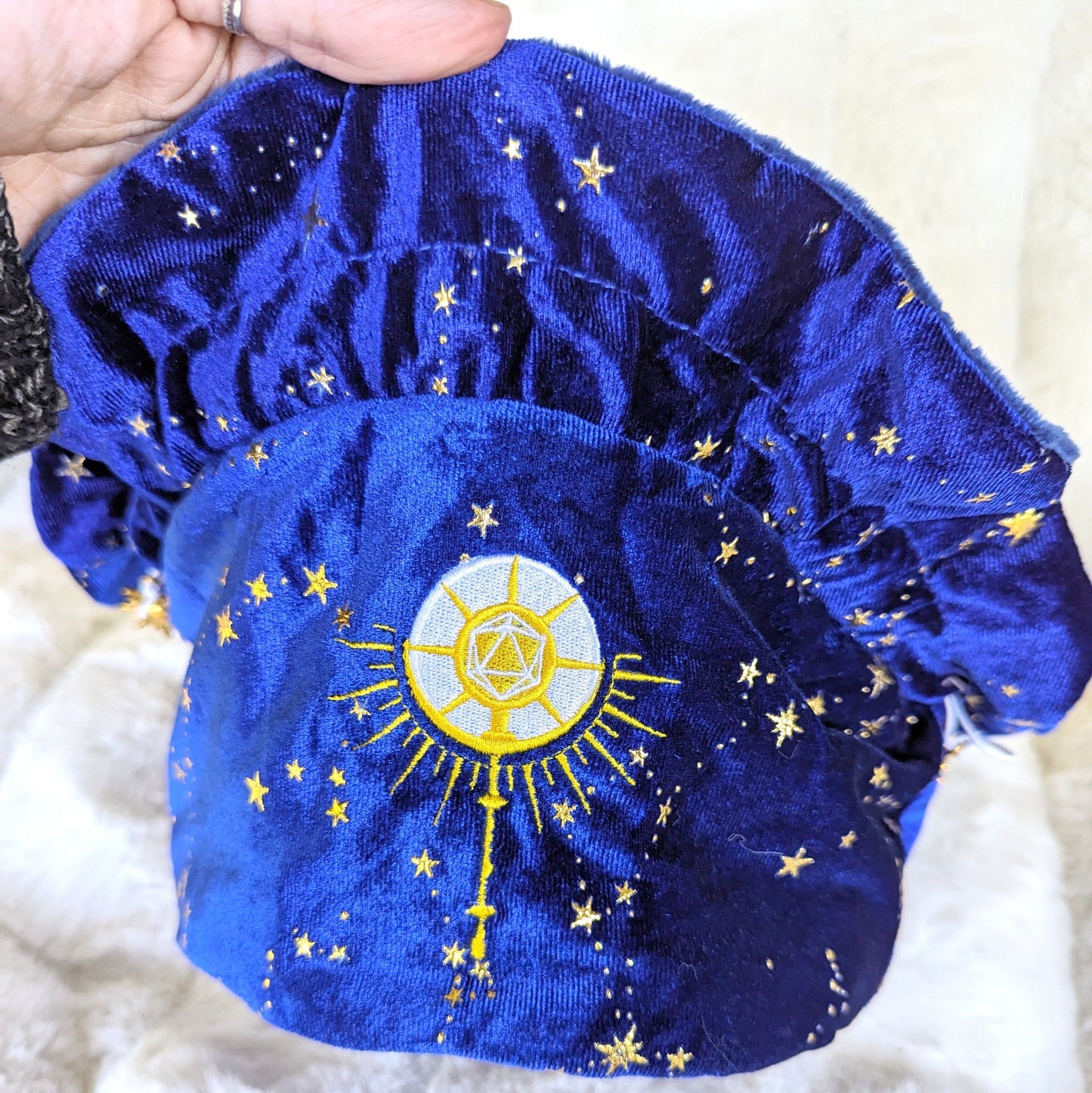 Cleric dice bag in starry blue velvet with embroidered D20 mace and sun rays, featuring golden stars and drawstrings with sun charms.