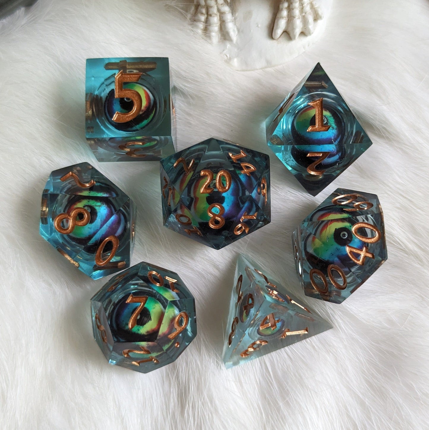 Colorful liquid core DnD dice set with moving eye design on a white background.