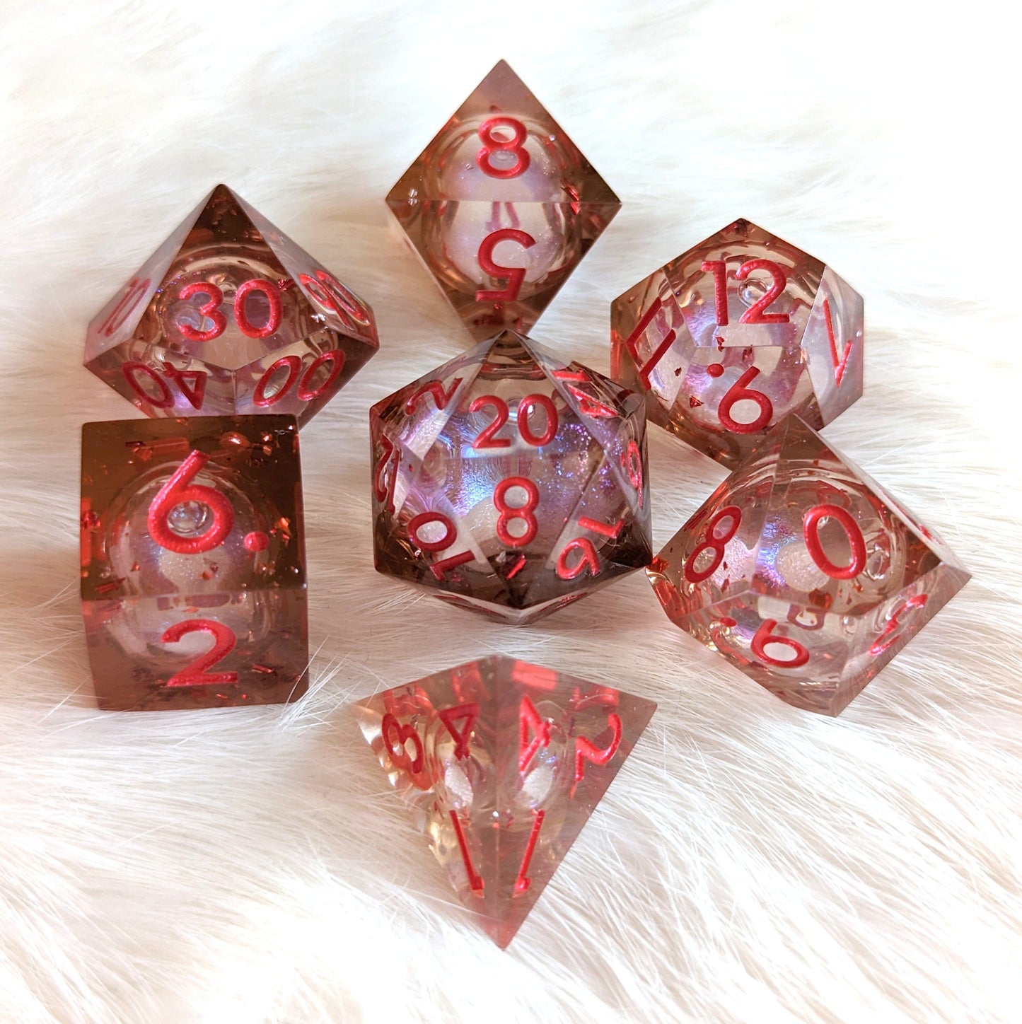 Crimson Liquid Core Sharp Edge Resin DnD Dice Set with swirling shimmer on white background.