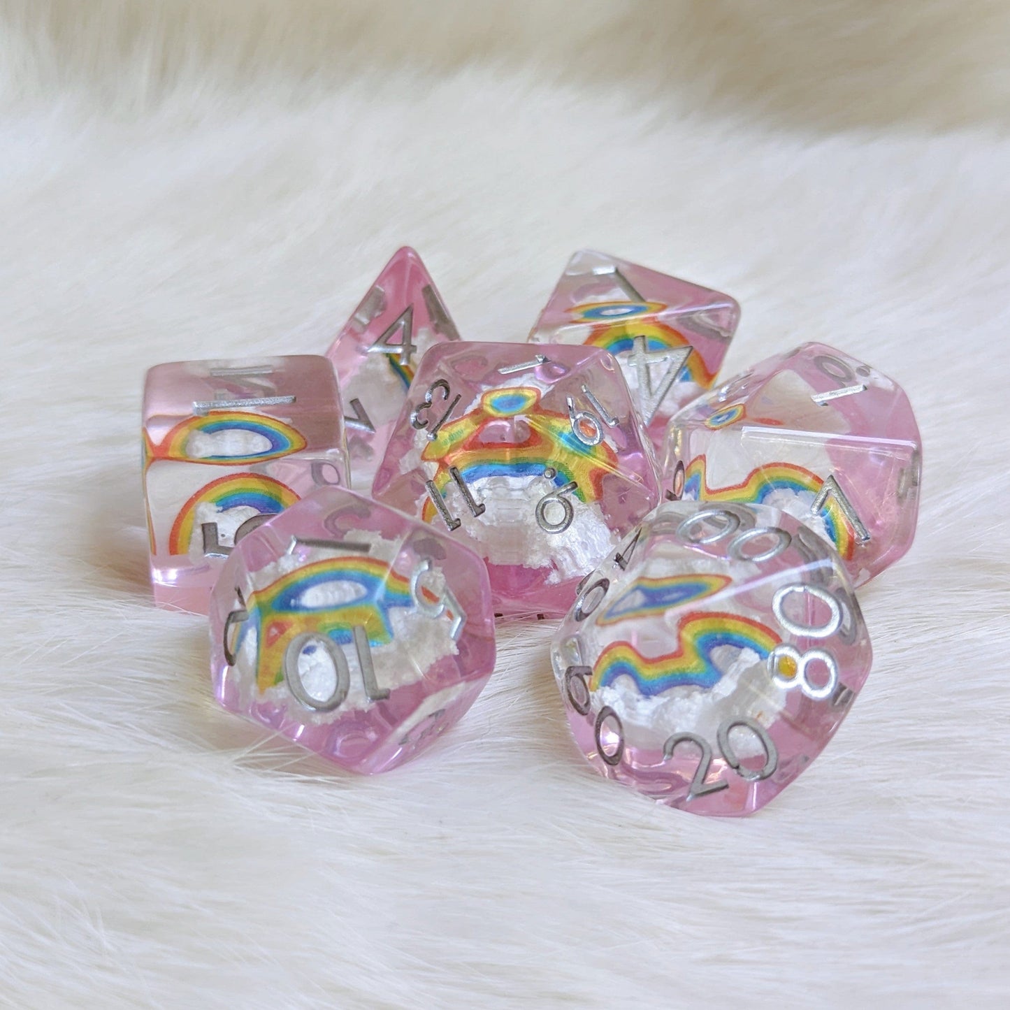Dreamy Rainbows and Clouds dice set with clear resin, featuring white clouds and bright rainbows on a light purple background.