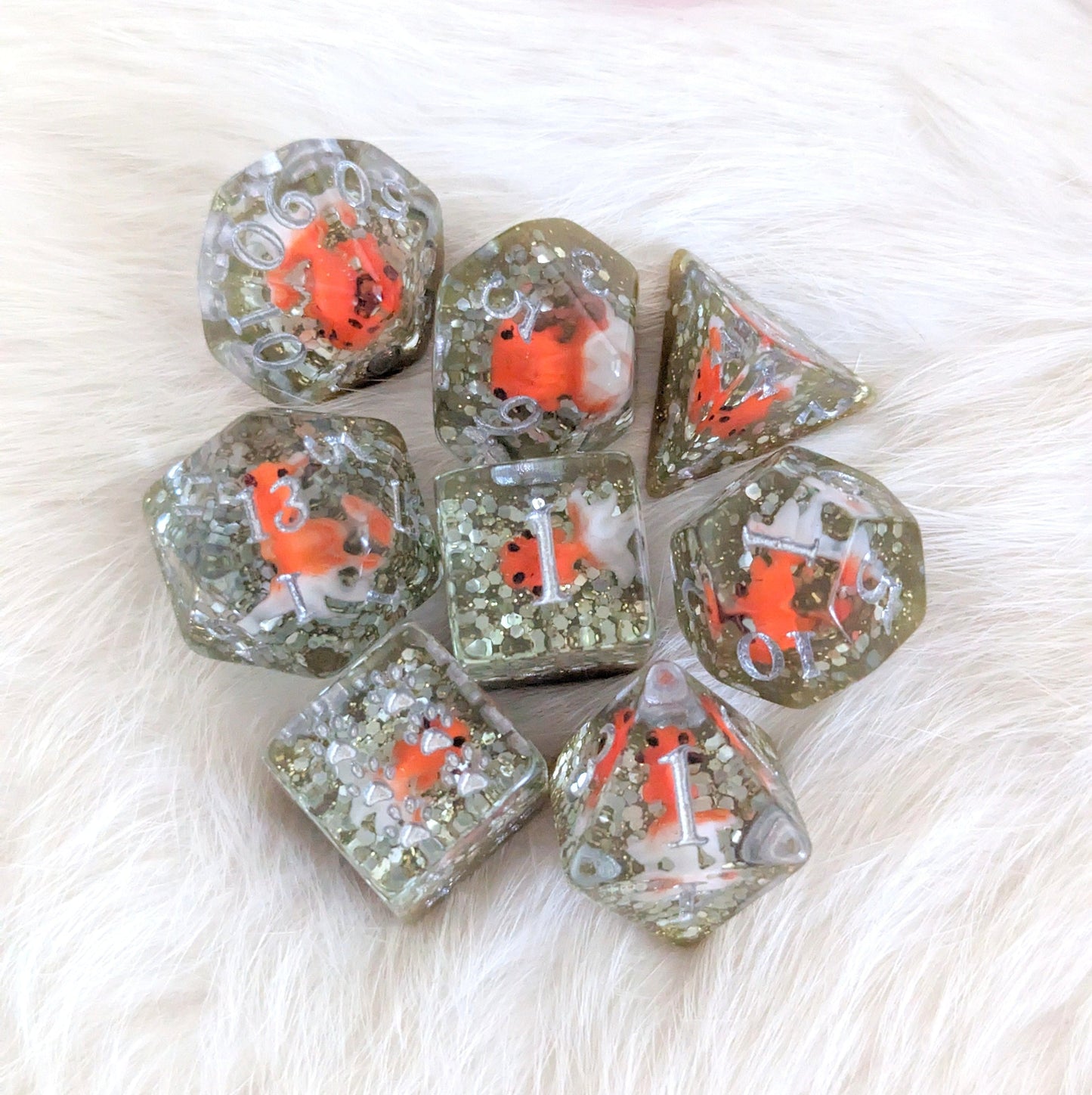Fancy Goldfish Dirty Pond Dice Set with bright orange fish in glitter resin on a white background, perfect for tabletop games.