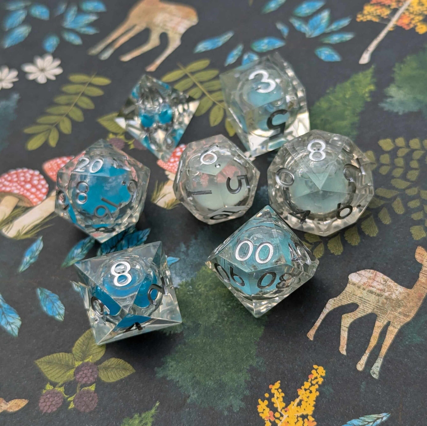 Frostbound Shimmer Liquid Core DnD Dice Set with icy blue glitter on a forest-themed background