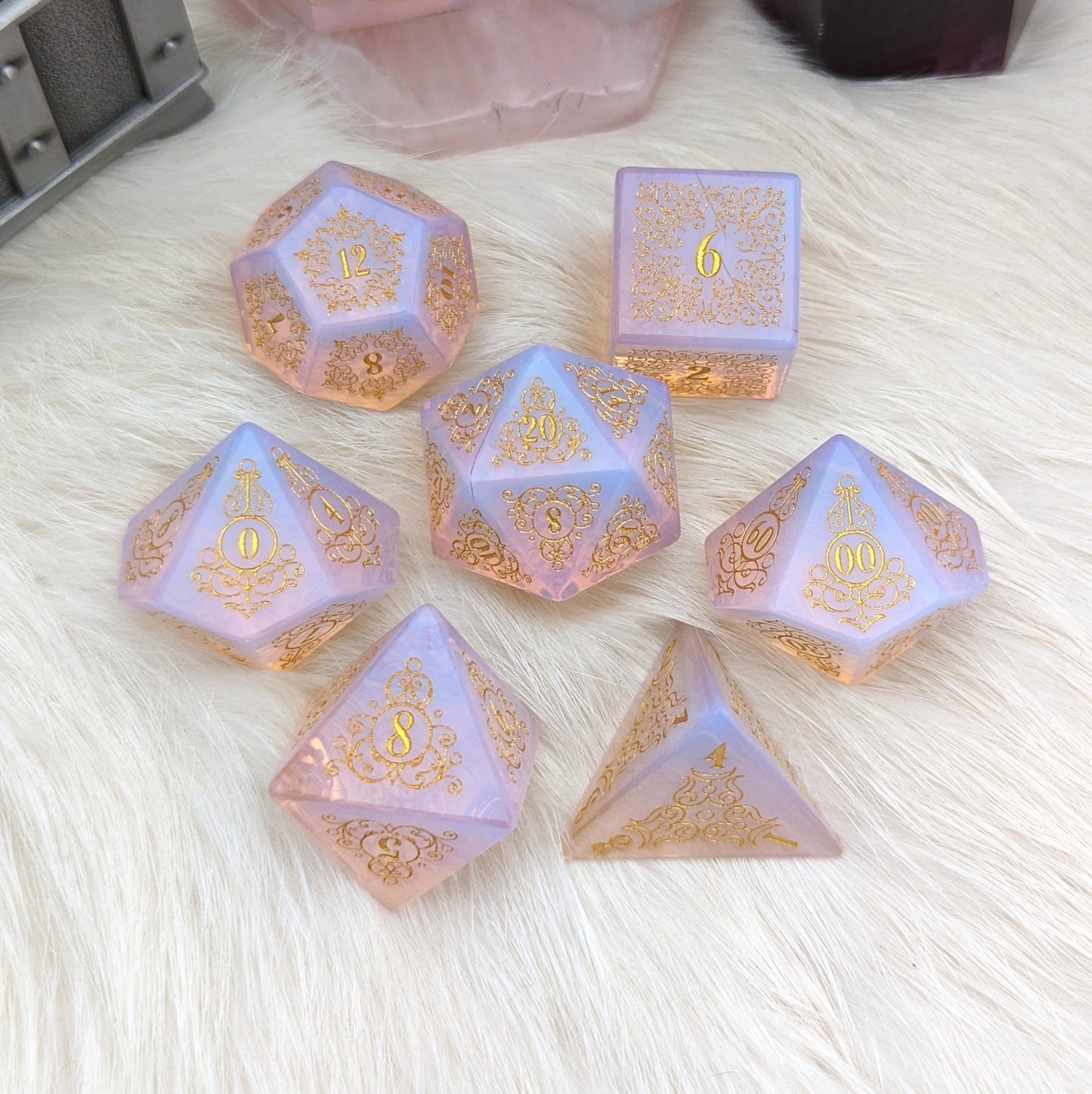Glowing Pink Opalite Gemstone Dice Set with Garden Gate design featuring floral and swirl patterns on a soft surface