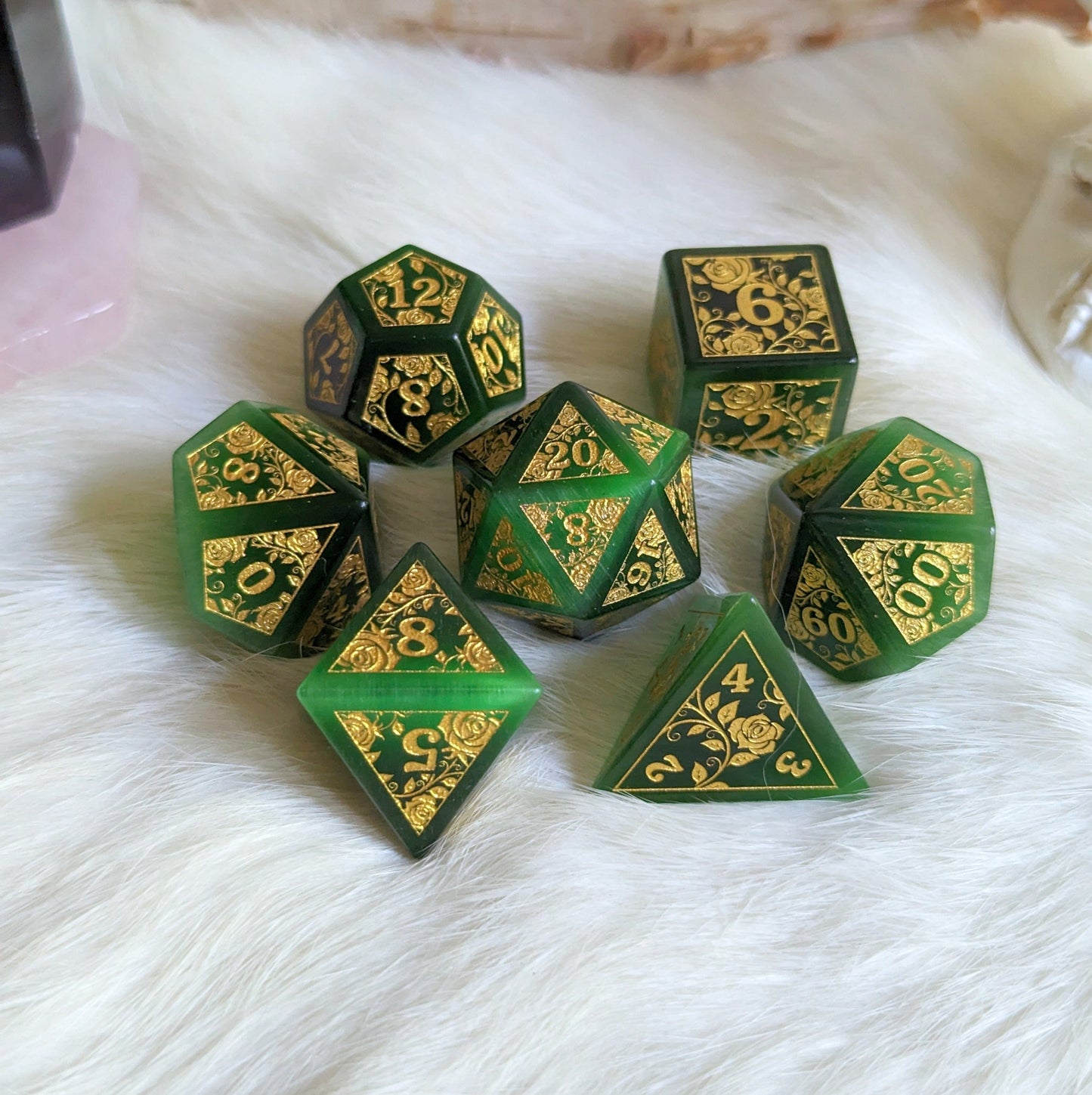 Green Cats Eye Rose Dice Set with gold rose and vine design, displayed on a soft surface, perfect for Dungeons & Dragons.