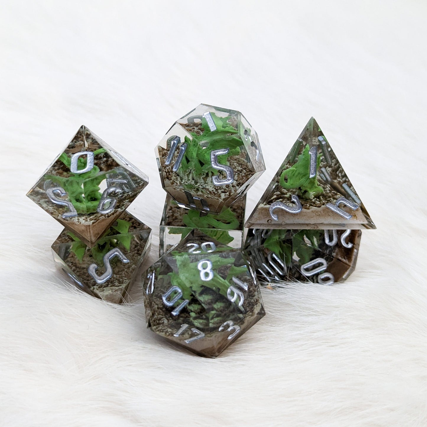 Green Dragon Sharp Edge Resin DnD Dice Set with mini dragons inside, 7 piece polyhedral for tabletop RPGs on white background.