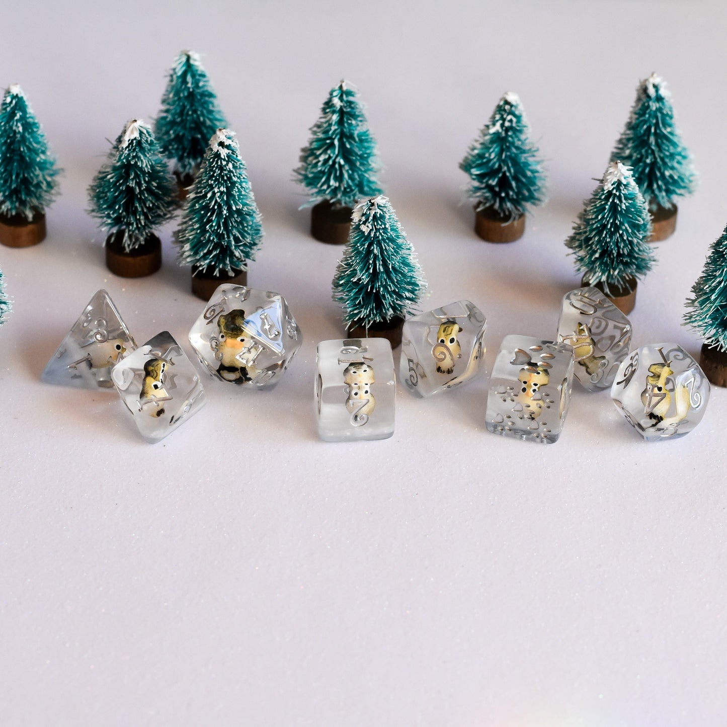 Horned Owl Dice Set with miniature owls in clear resin surrounded by small pine trees.