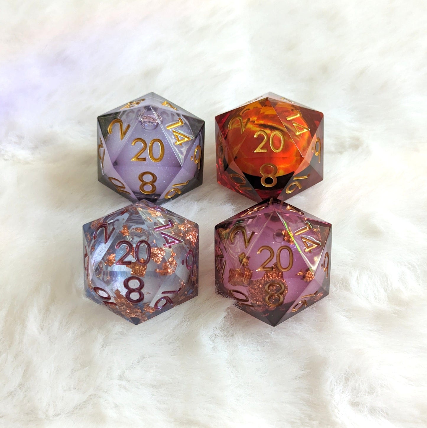 Four large liquid core D20 dice with swirling glitter, ideal for tabletop RPGs like Dungeons and Dragons, on a soft white background.