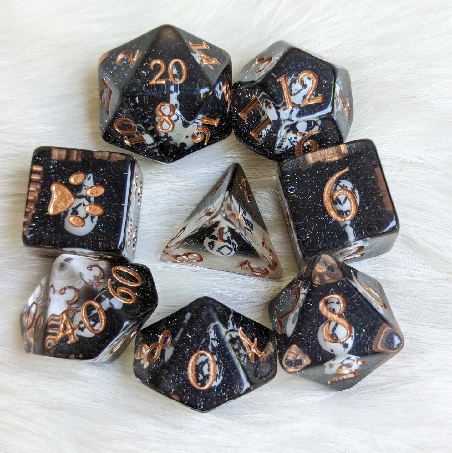 Raven Queen themed 8-piece Mementos Dice Set with bird skull design and enchanting fantasy font on a furry background.