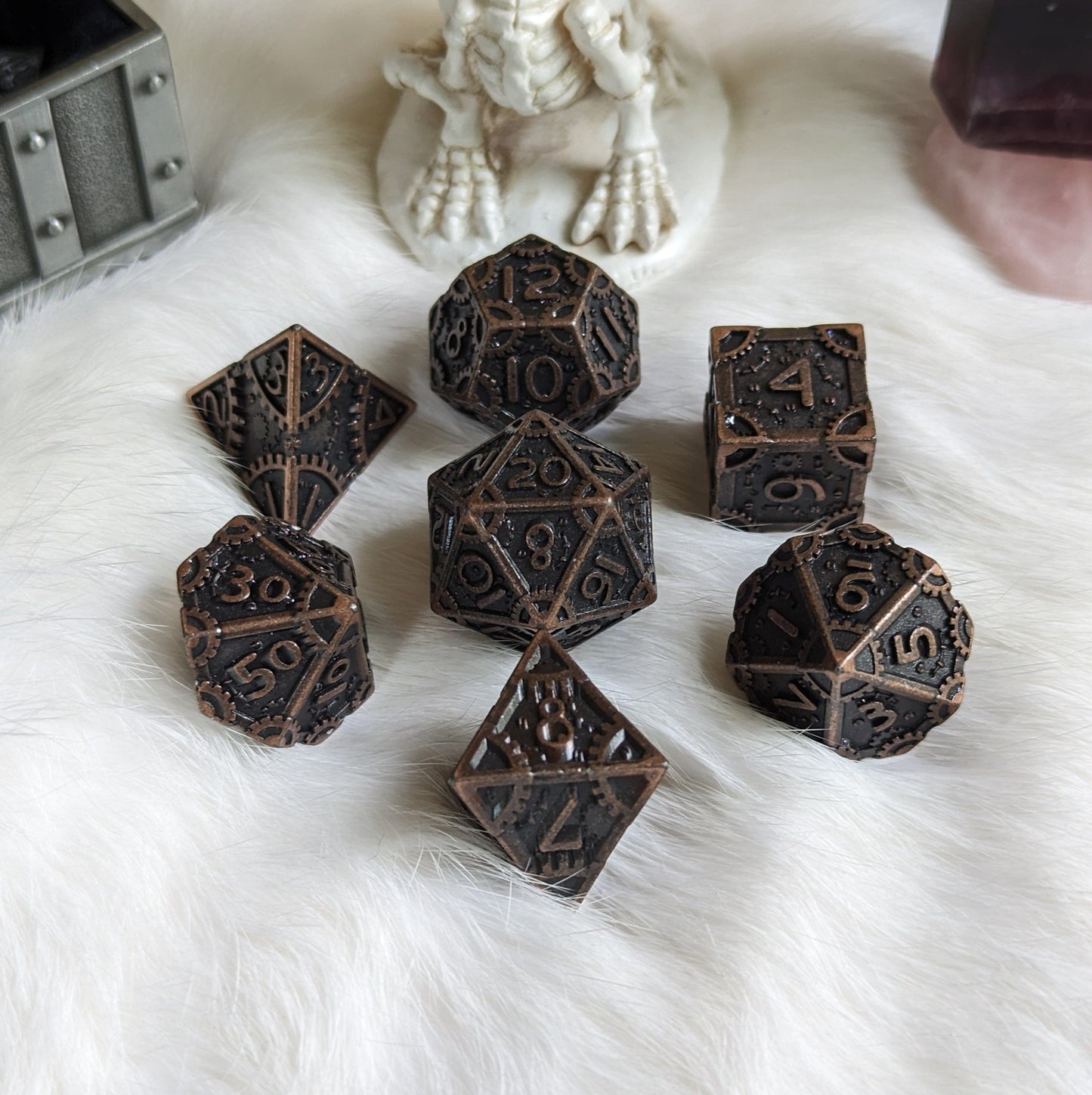 Bronze Metal Gears Dice Set with clockwork design and polyhedral shapes on a white fur background, ideal for tabletop RPGs.