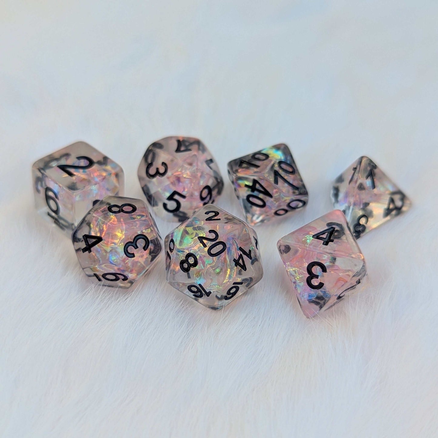 Moonlight Fantasy TTRPG Dice Set with pink iridescent cellophane and black numbers on a soft white background