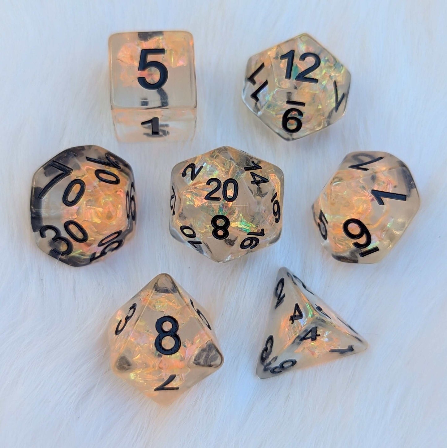 Phoenix's Rebirth TTRPG Dice Set with orange iridescent cellophane, black numbers, and clear resin on display.