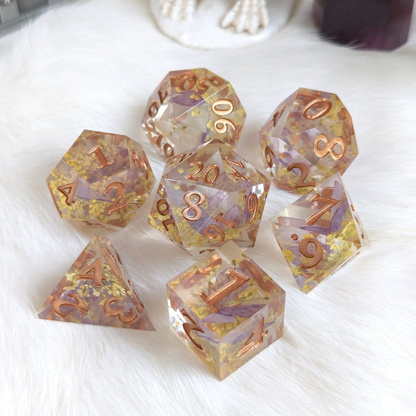 Purple Butterfly and Yellow Flower DnD Dice Set with Copper Font, Featuring Seven TTRPG Dice on a White Surface