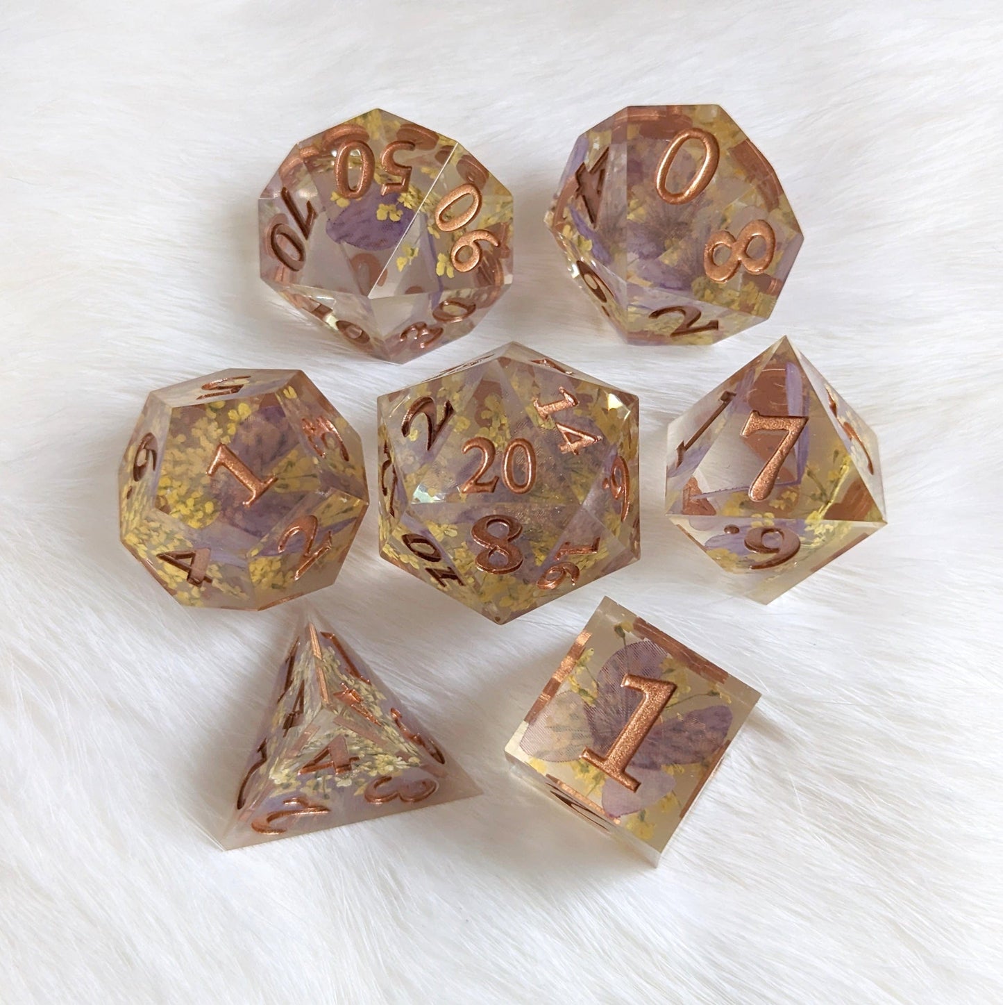 Purple butterfly and yellow flower DnD dice set with copper numbers on a white background.