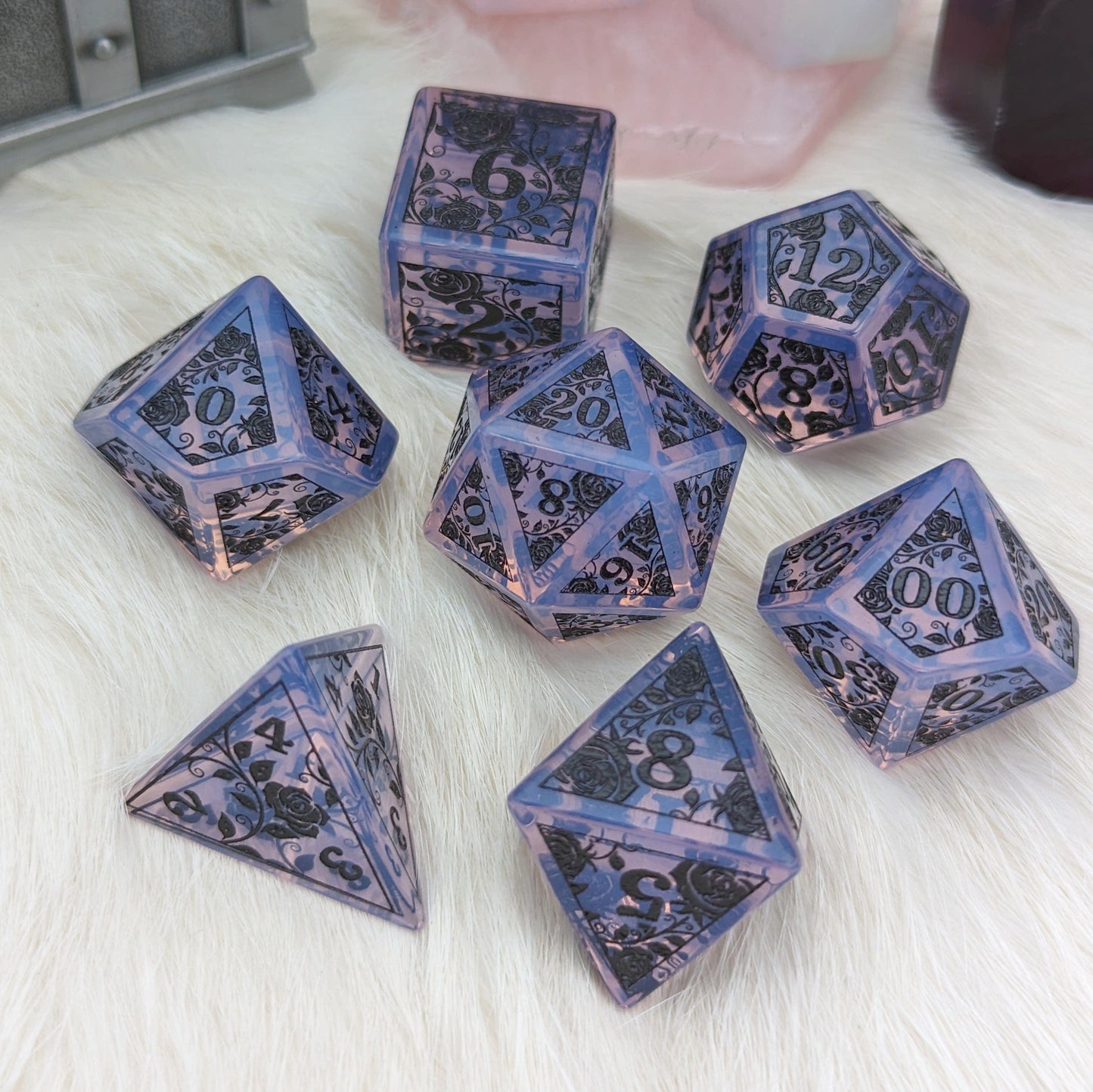 Purple opalite rose dice set with black engraved rose designs on a white surface.