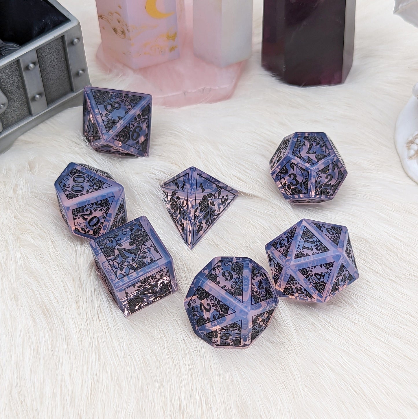 Purple Opalite Rose Dice Set with black rose and vine engravings on fluffy white surface. Unique gemstone dice perfect for Dungeons & Dragons.