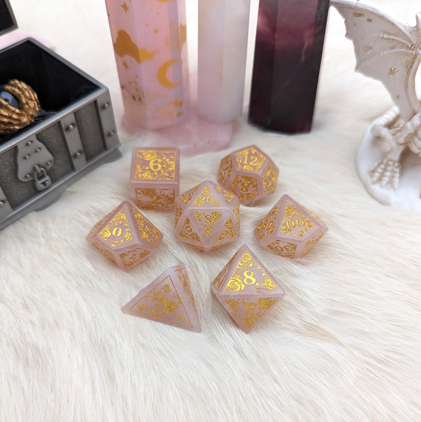 Rose quartz dice set with gold rose and vine design, perfect for Dungeons & Dragons. Unique and enchanting gemstone dice collection.