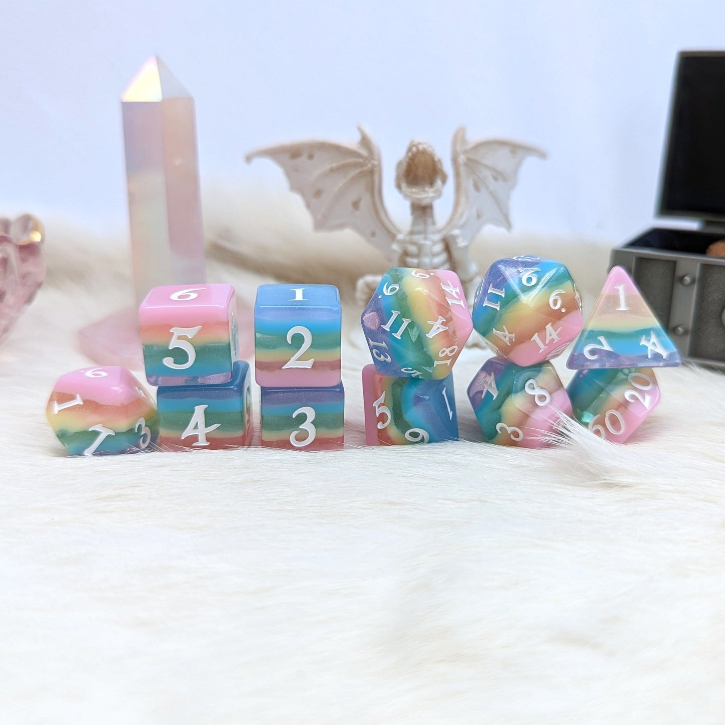 Pastel rainbow stripe DnD dice set with 11 pieces including extra D20 and D6, featuring opaque and clear glitter layers.