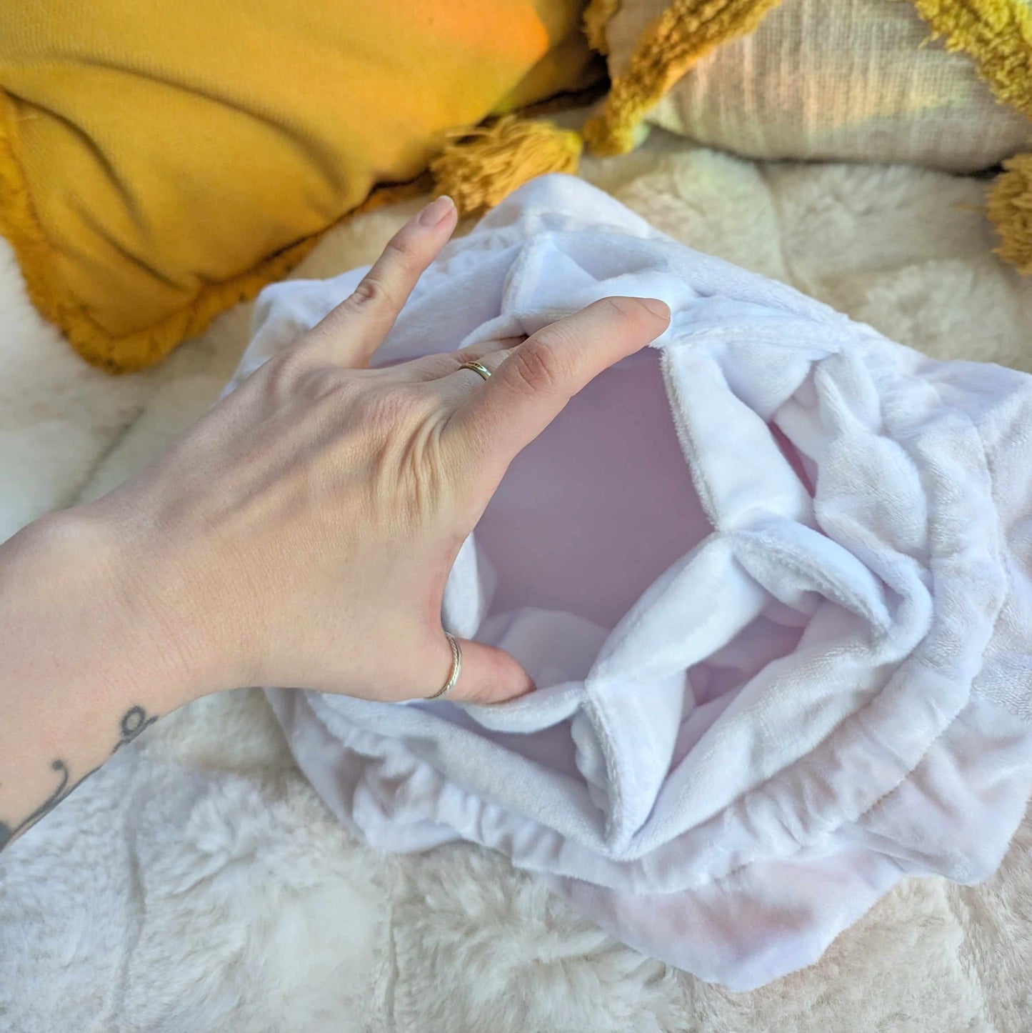 Open view of the starry pink dice bag showing its soft white interior and multiple pockets on a cozy surface.