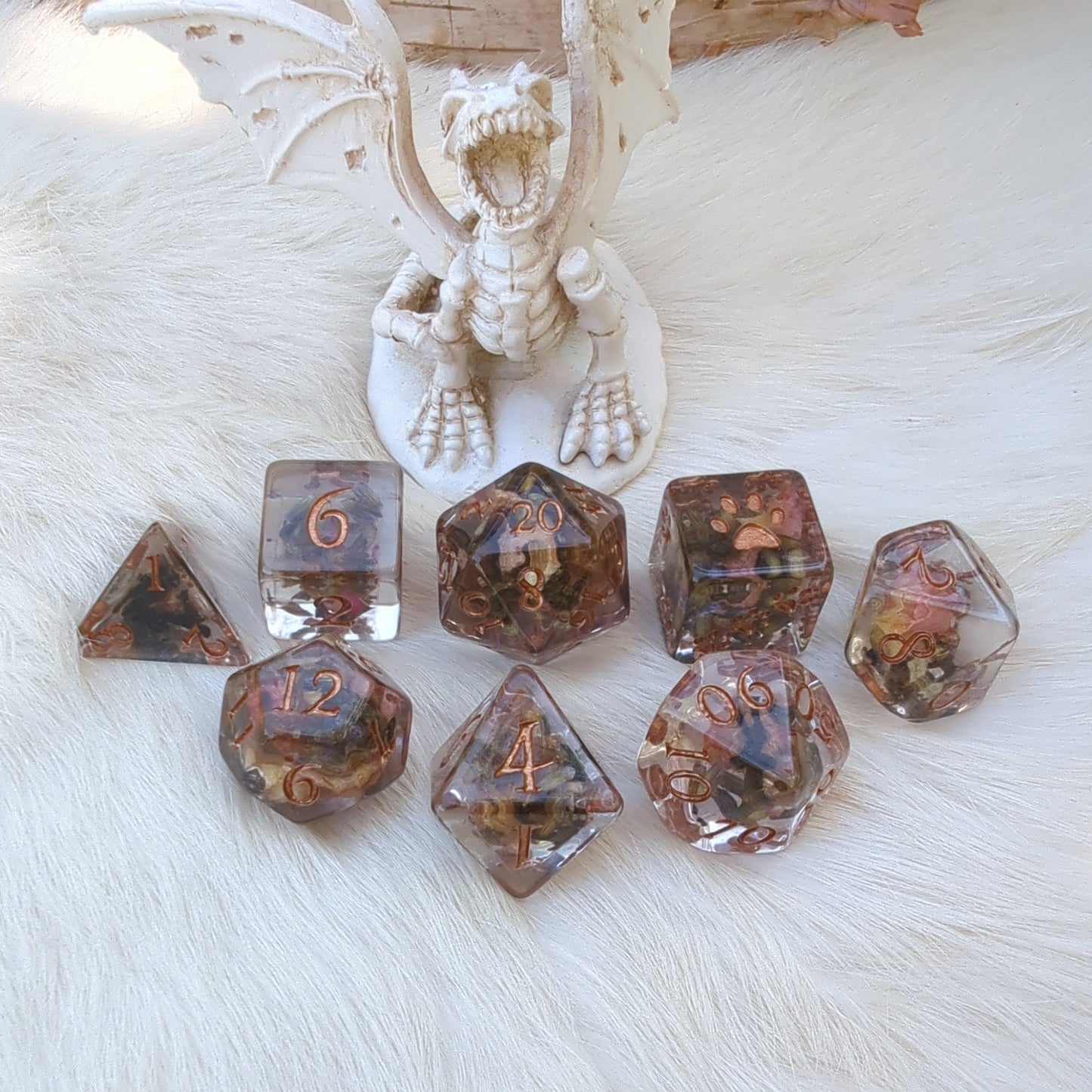 8 piece DND dice set with dried tea, rose petals, and lavender flowers. Custom bronze font and extra D6, designed by Therin. No D20 logo.