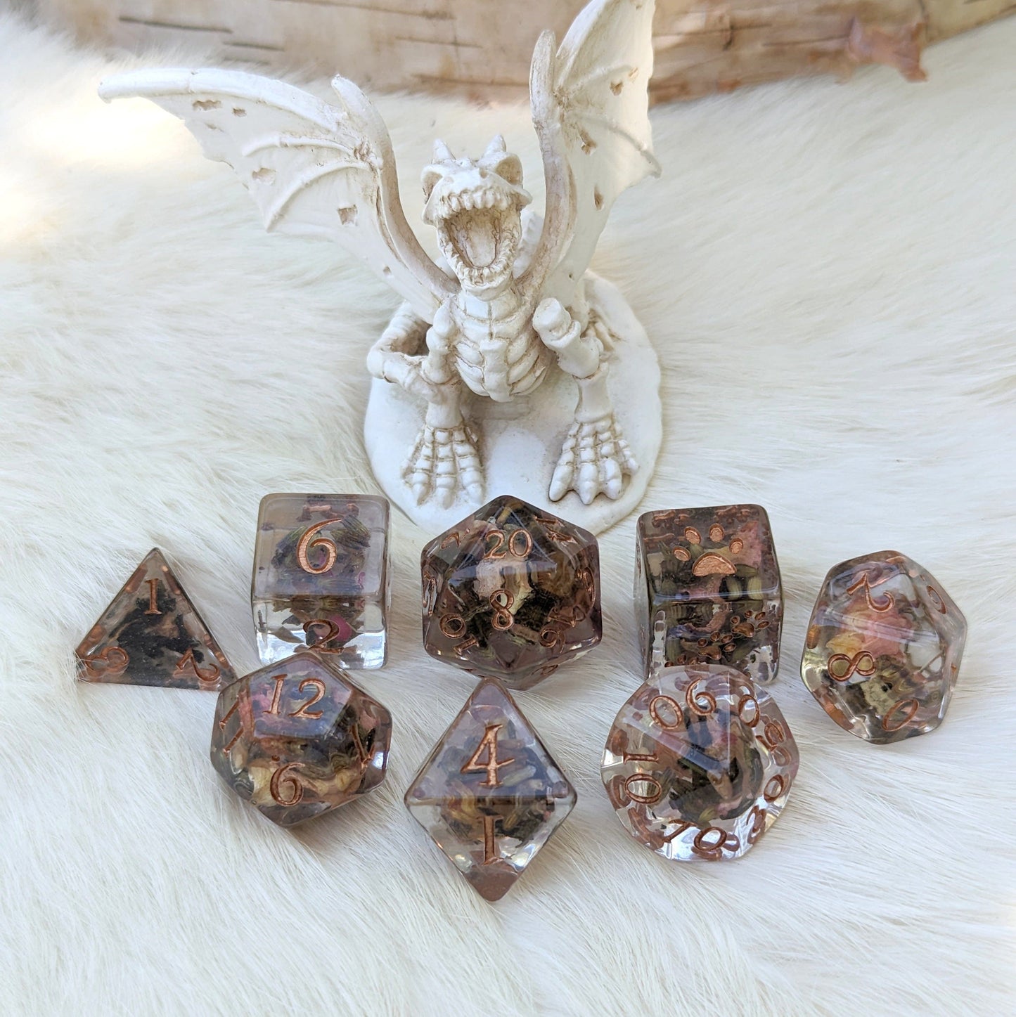 DND dice set with real dried tea and flowers, bronze numbers, displayed with dragon figurine; 8-piece set designed by Therin.