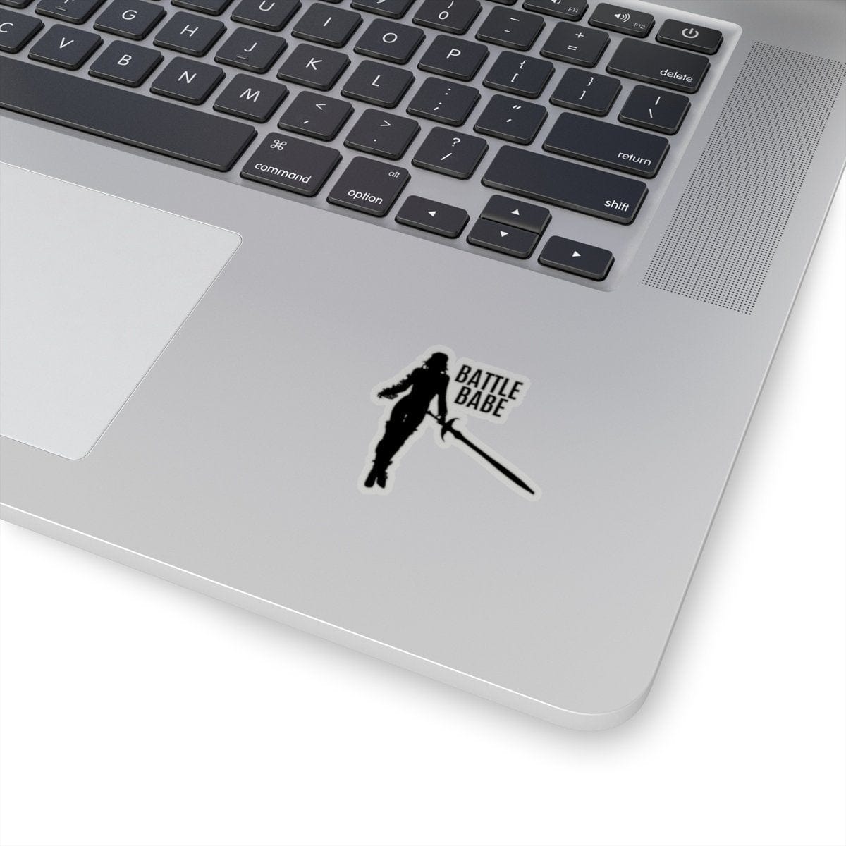 Battle Babe Sticker on laptop showing black silhouette with sword and text, 2x2 inch size, transparent background.