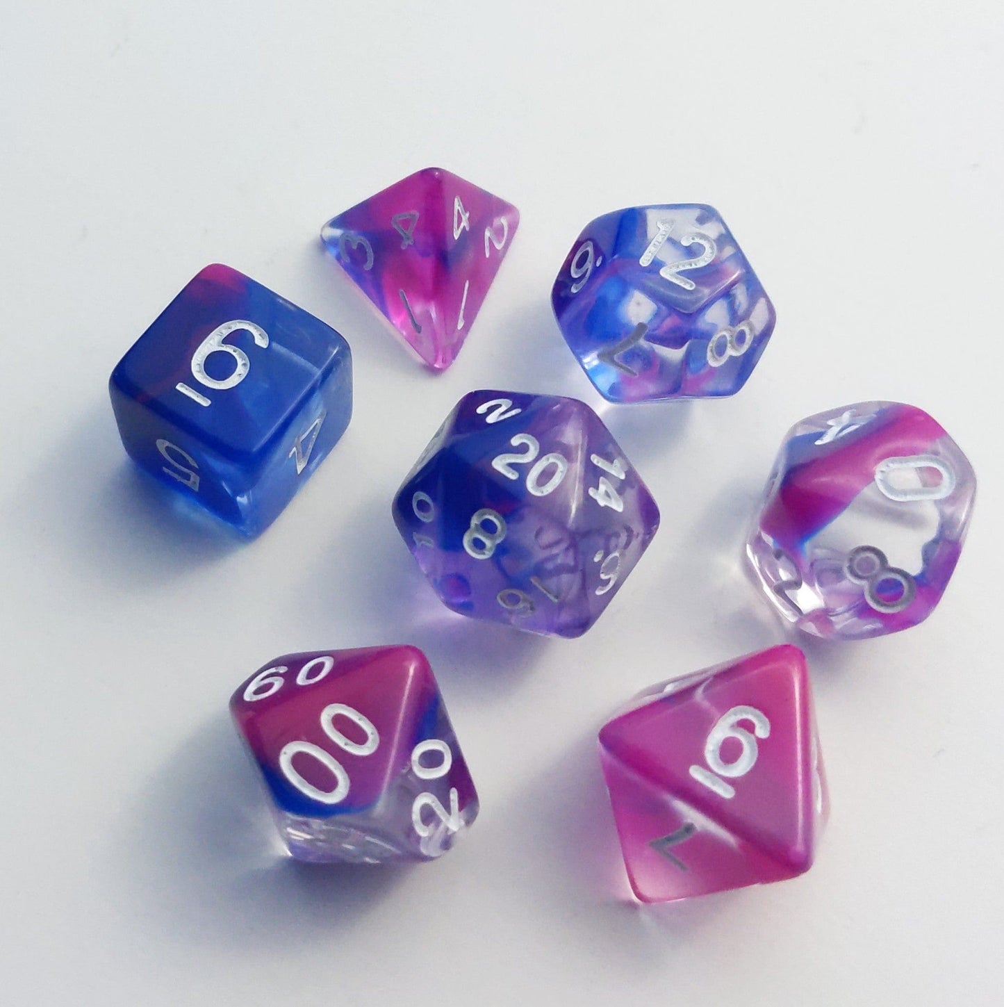 Blink Marble Dice Set with blue and pink swirls, 7-piece polyhedral set for TTRPGs, including D20 and D12 dice.