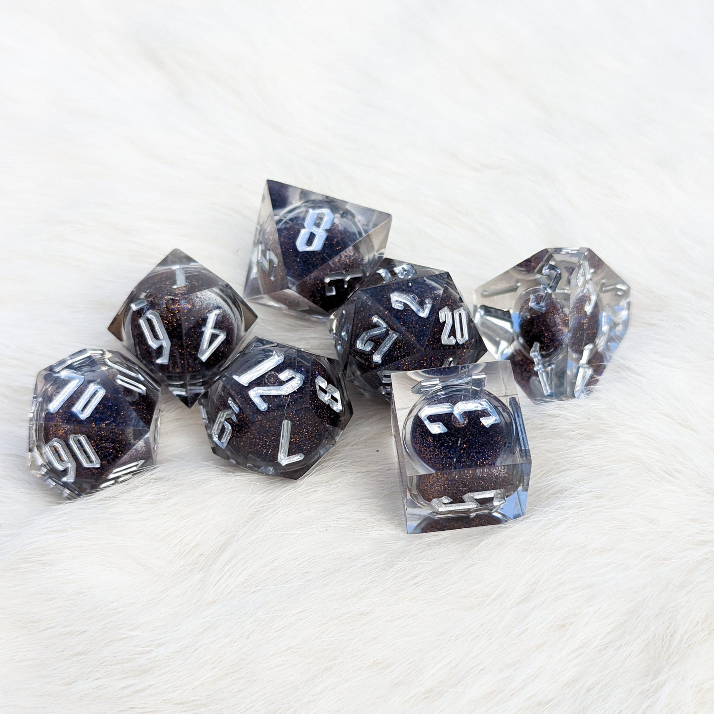 Blue and gold clear liquid core sharp edge resin DnD dice set with glitter, featuring unique D4 shape for tabletop games.