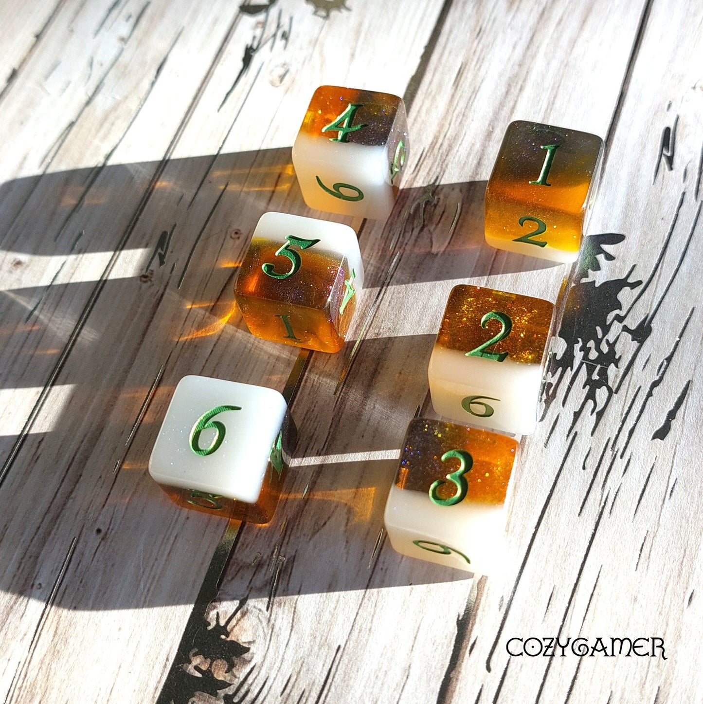 Calico Hazy IPA D6 dice set in cat colors, beer-themed gaming dice with green numbers on wood background.