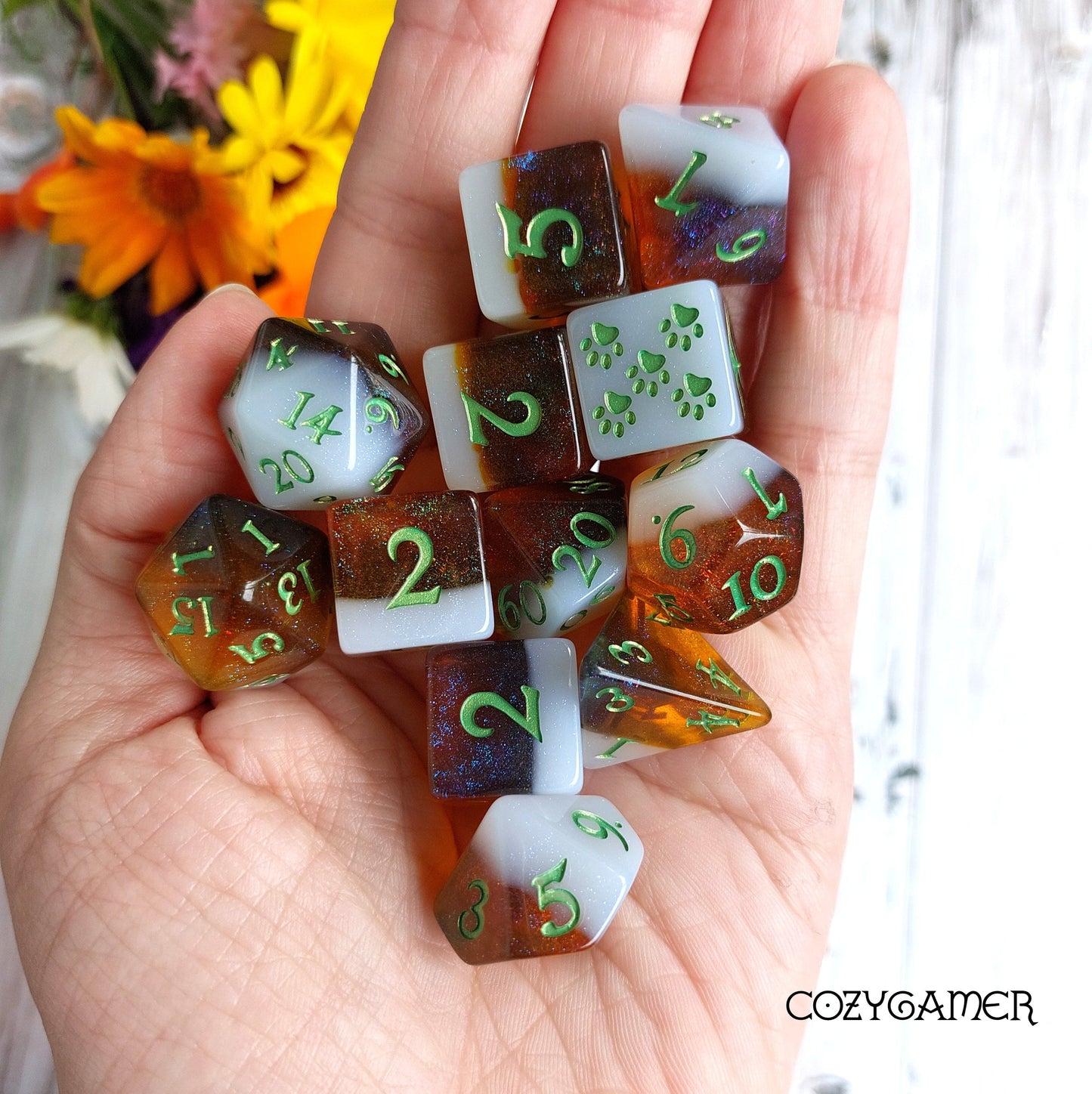 Calico Hazy IPA dice set in hand, featuring beer-themed DND dice with calico cat colors, including D6 and special paw die.