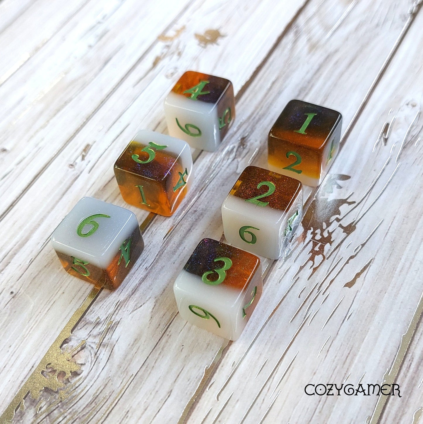 Calico Hazy IPA D6 dice set in cat colors with green numbers on a wooden surface, beer-themed DnD dice by CozyGamer.