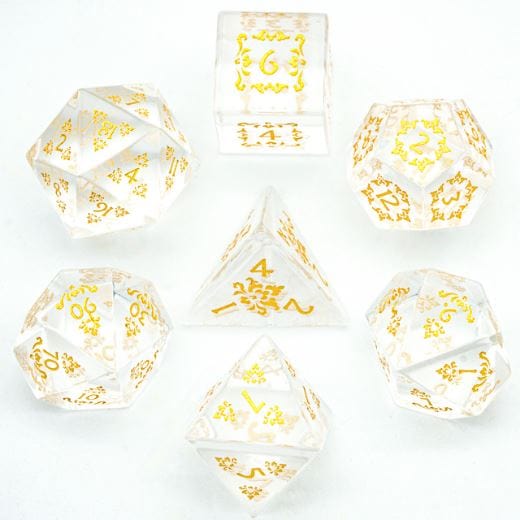 Carved Glass Dice Set with gold details, 7-piece TTRPG dice, displayed on a clear surface.
