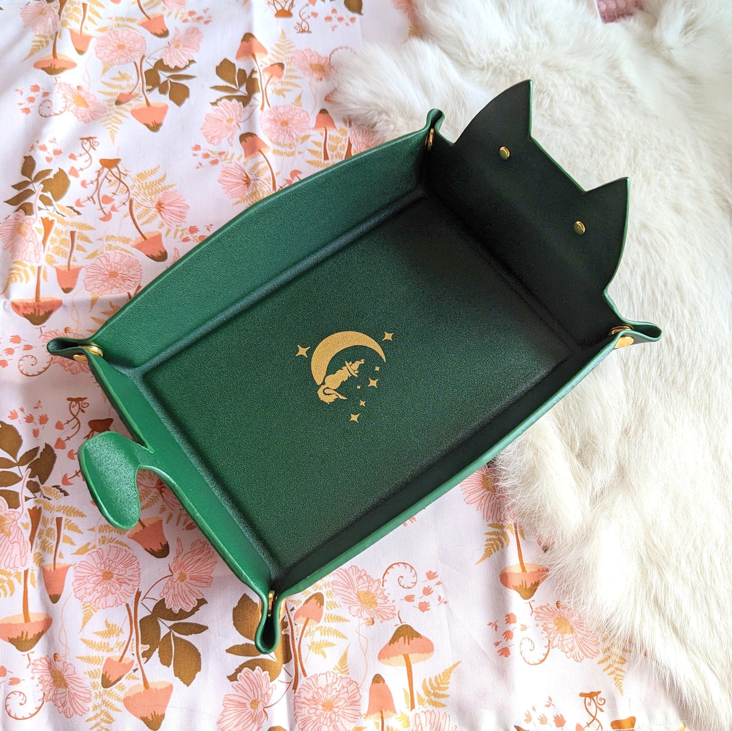 Emerald cat shaped dice rolling tray for DnD, featuring a snap design and flat folding for easy transport on floral background.