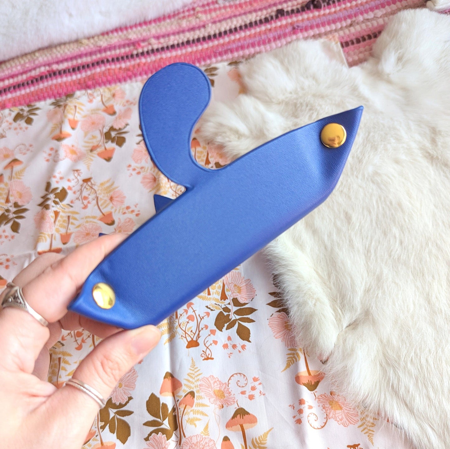 Indigo cat-shaped dice rolling tray folded for portability with snap buttons, perfect for DnD gaming sessions.