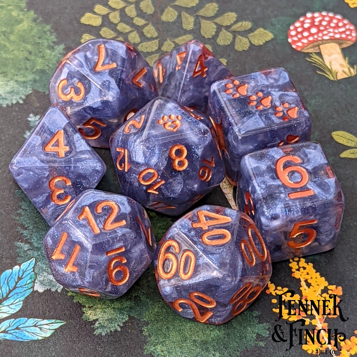 Ceanothus 8 piece dice set with copper font on clear resin and blue violet clouds, featuring custom cat wizard and paw heart designs.
