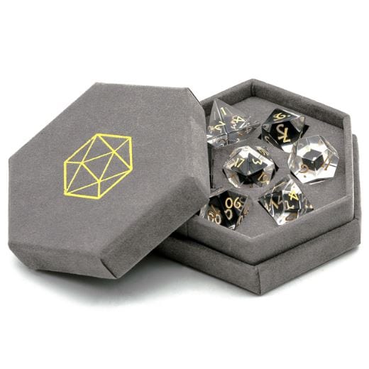 Clear glass gemstone dice set with gold font in hexagonal felt box, perfect for tabletop role-playing games.